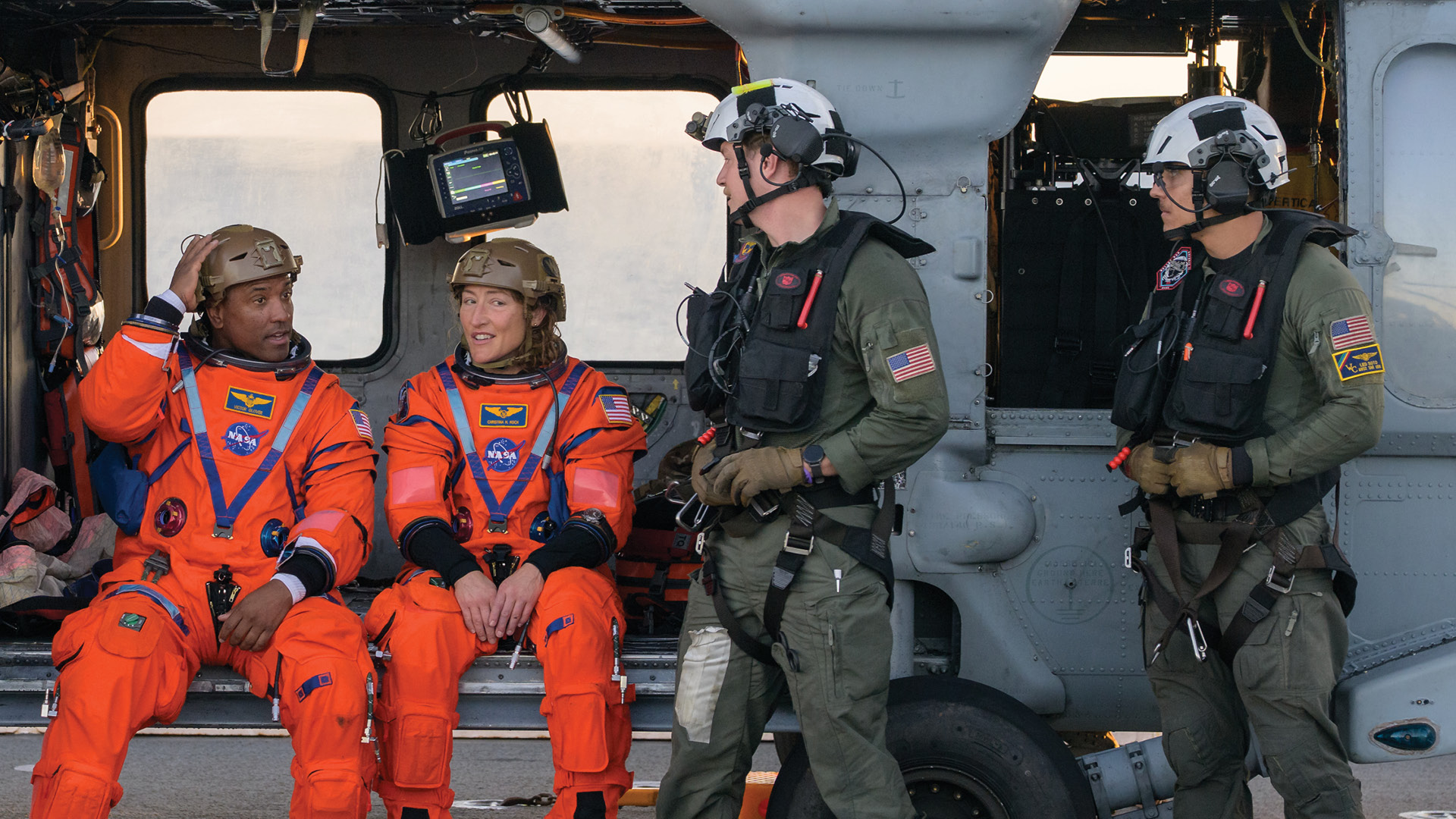 NASA astronauts and rescue team sitting in a helicopter wearing Team Wendy EXFIL LTP helmets