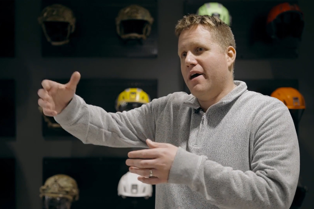 Man in grey zip up holding out his hands