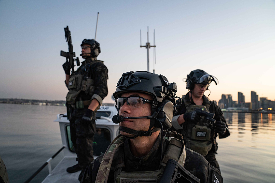 3 men in swat uniform on a boat and holding guns