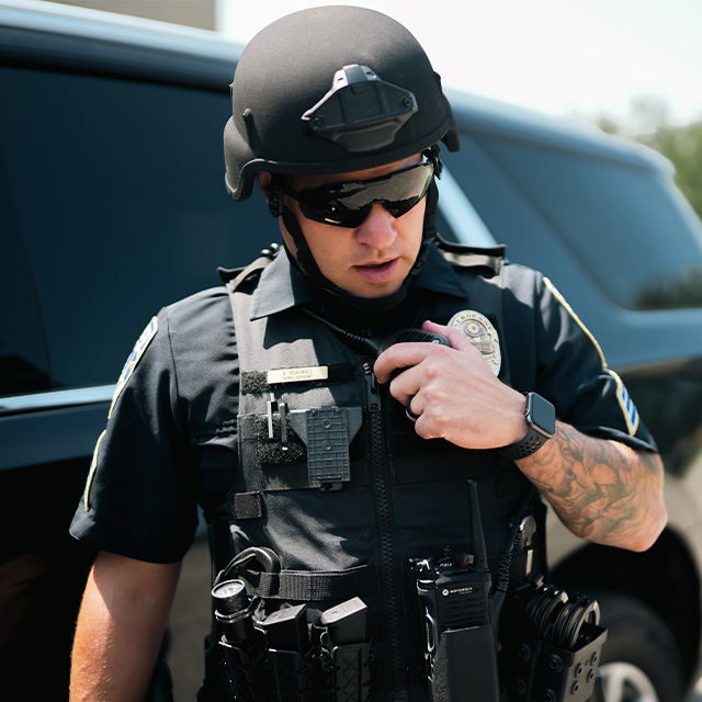 Policeman in helmet and sunglasses talking into radio